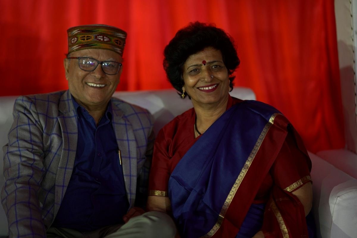 An older couple smiling together at a family occasion.