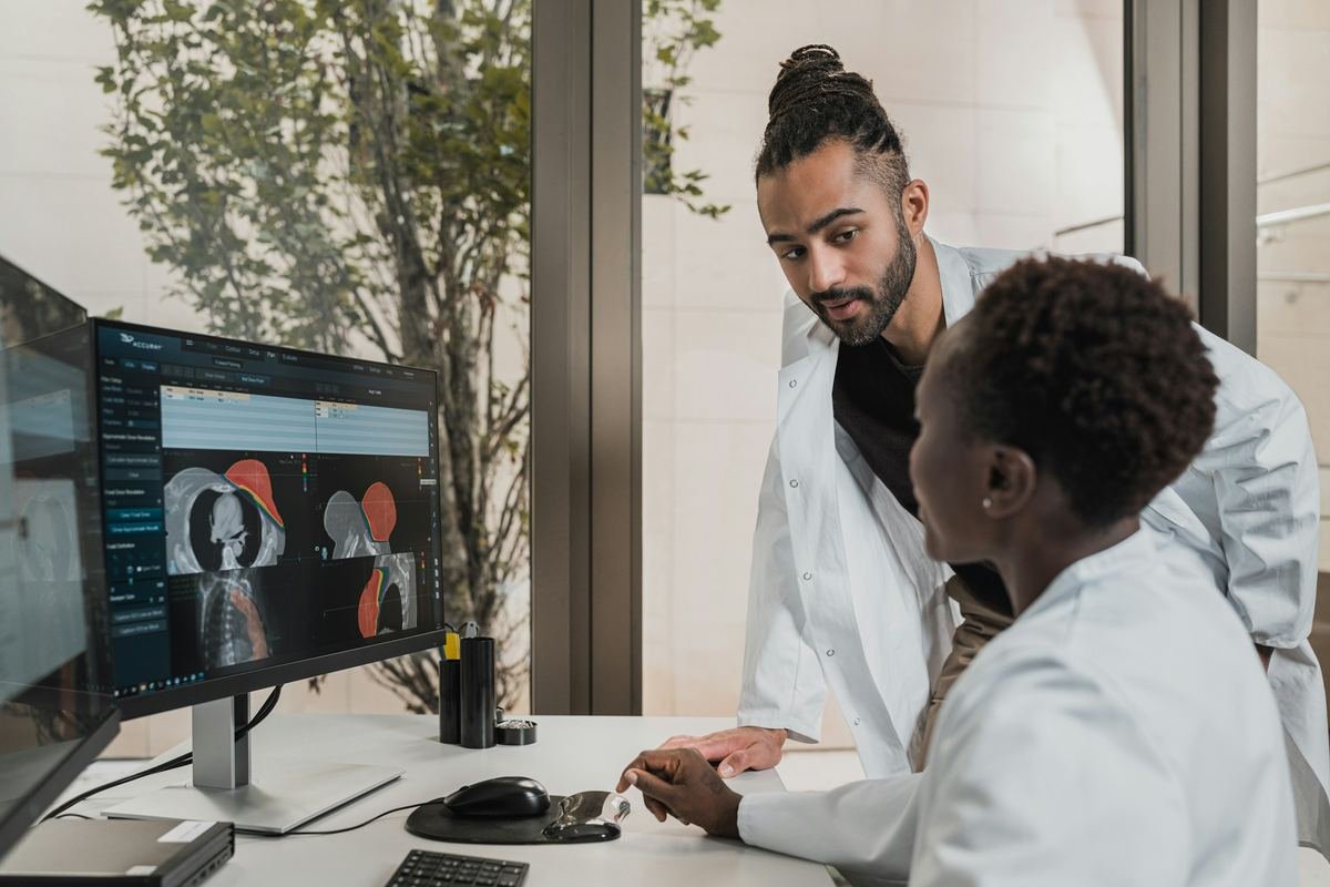 Two doctors discussing CT images on a monitor.