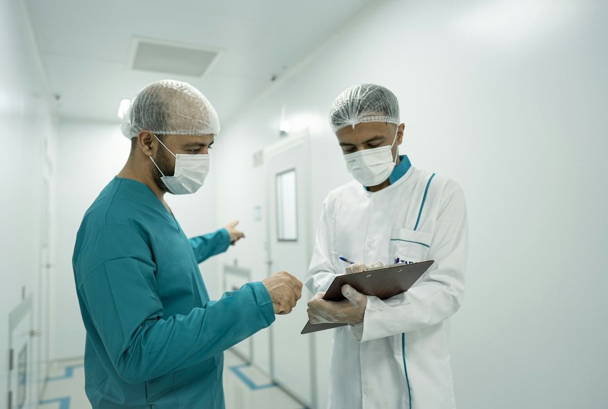 Two clinicians discussing notes in a hospital corridor.