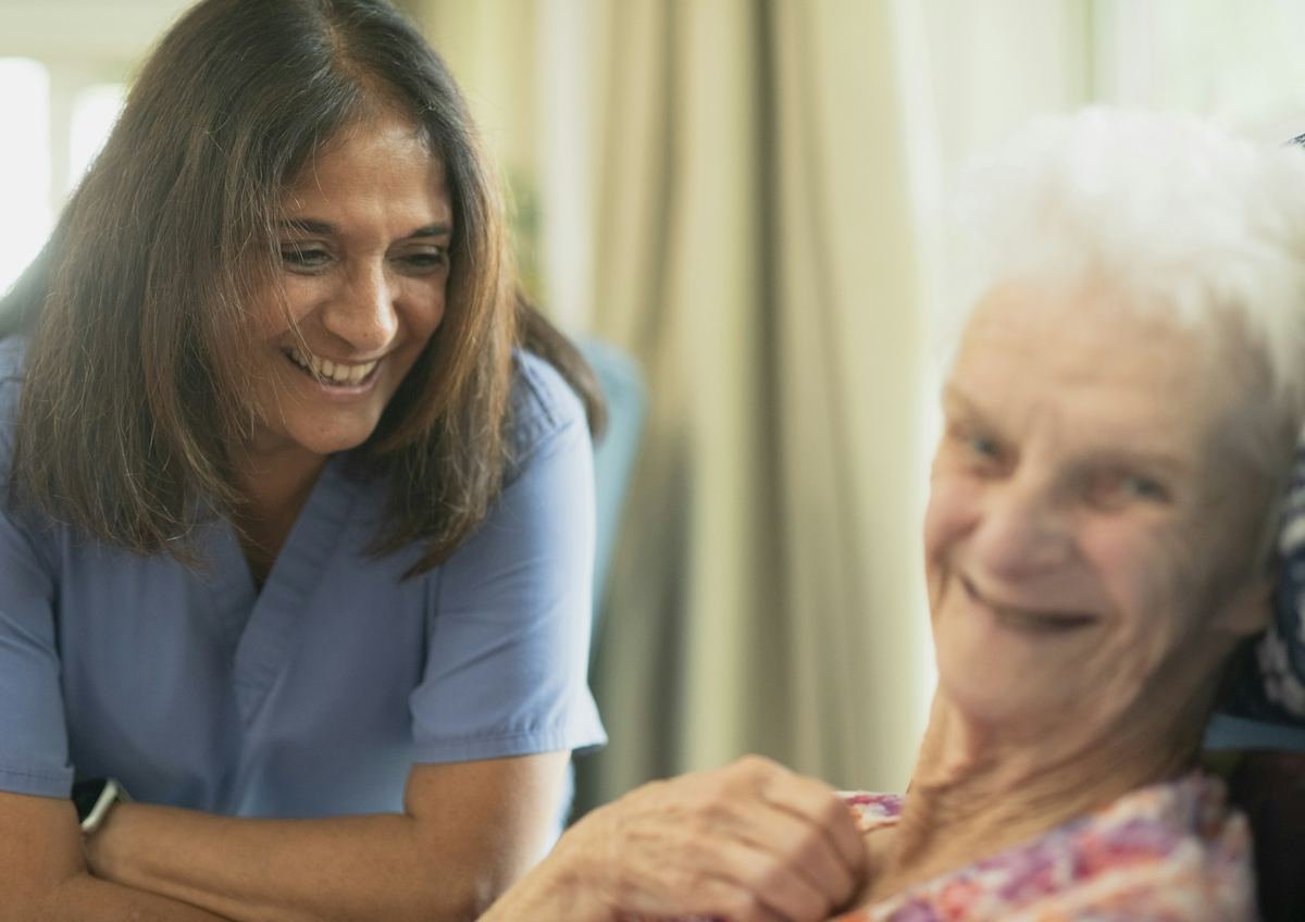 A nurse smiling with an older patient.
