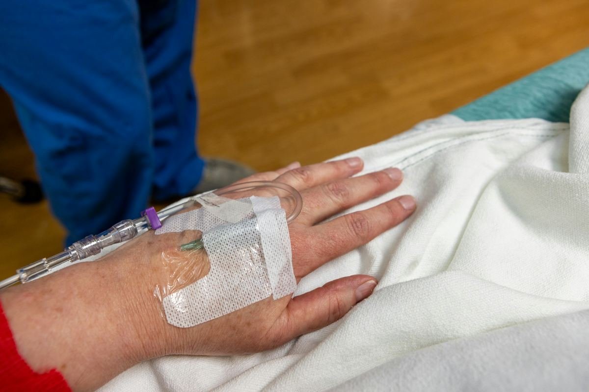 An intravenous cannula secured on a patient's hand.