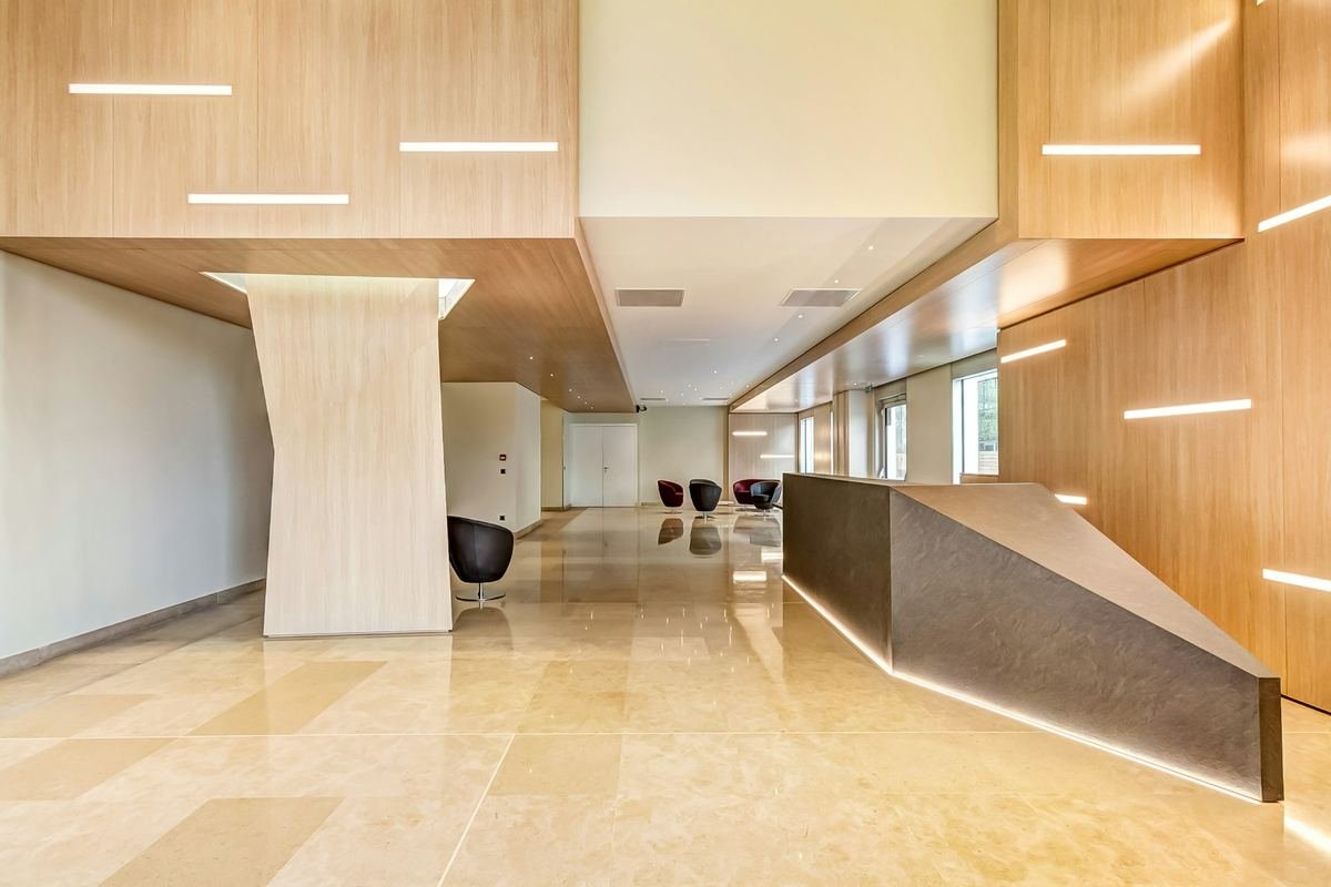 A warm, modern reception area with wood panels and soft lighting.
