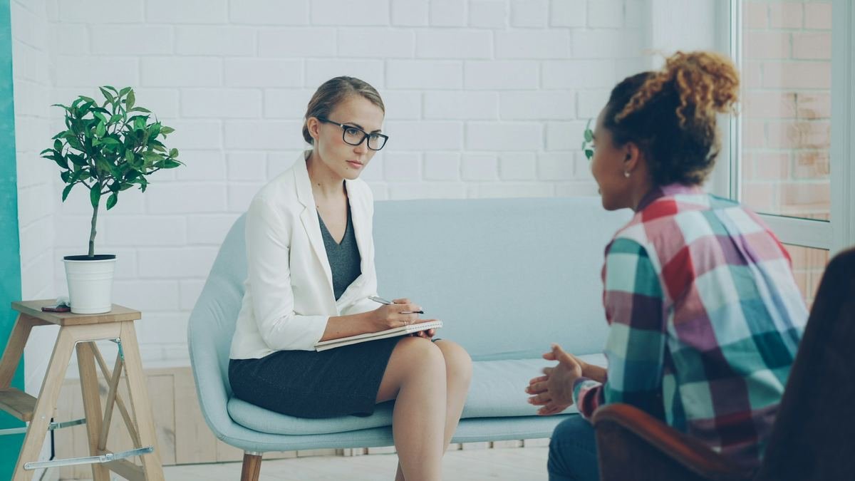 A clinician listening to a person during a consultation.