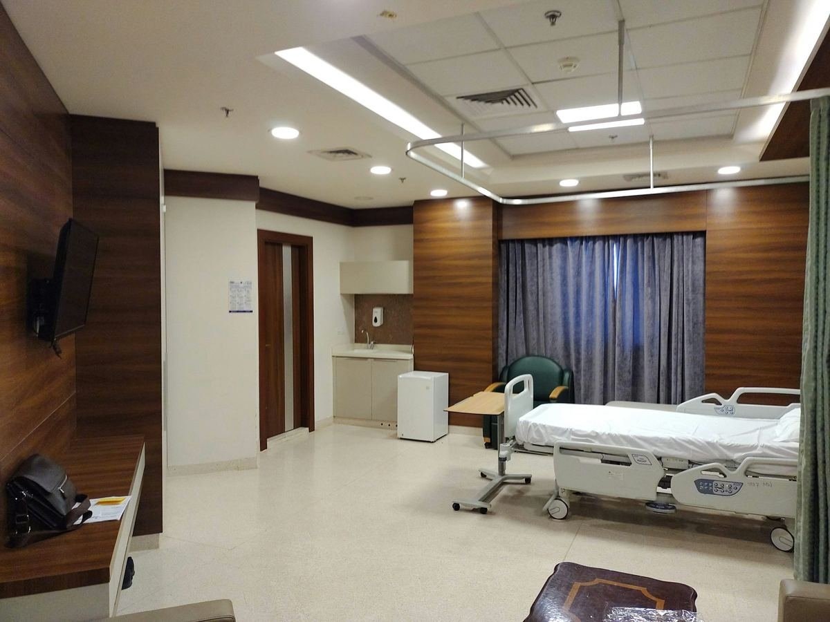 A quiet single treatment room with wood panelling and a bed.