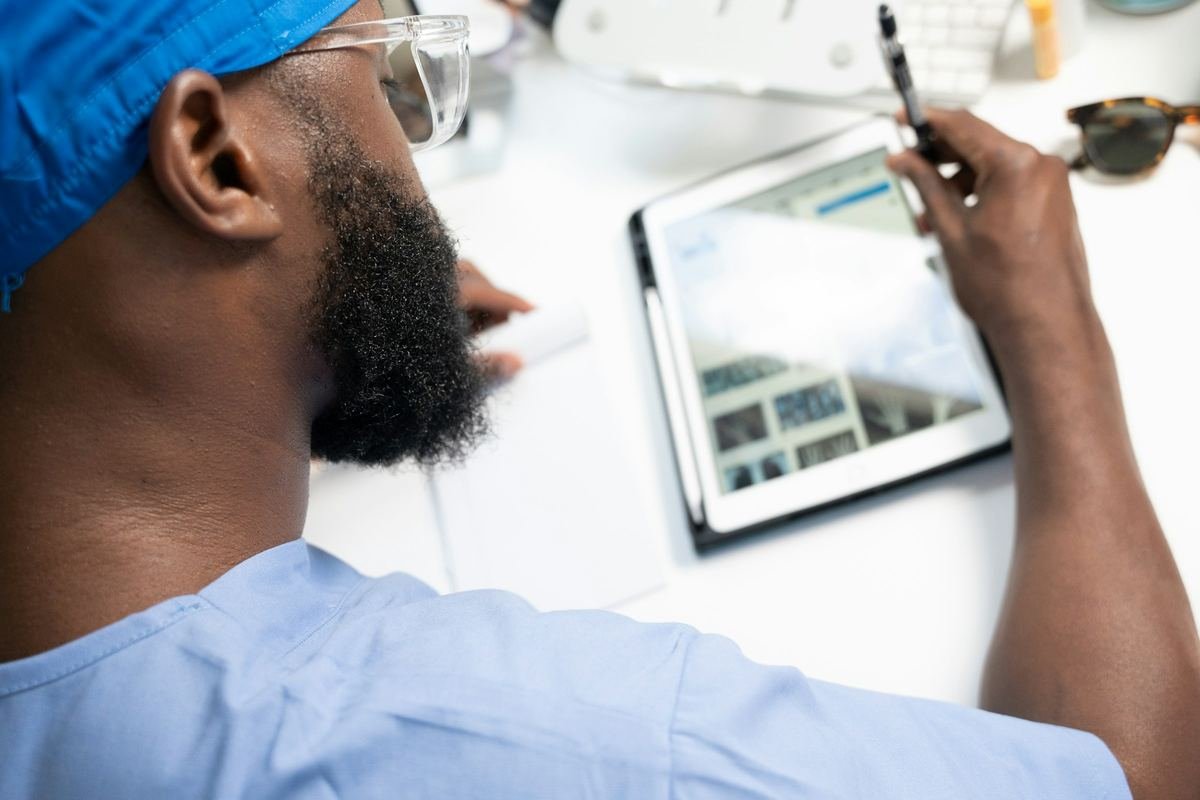 A clinician writing notes on a tablet.